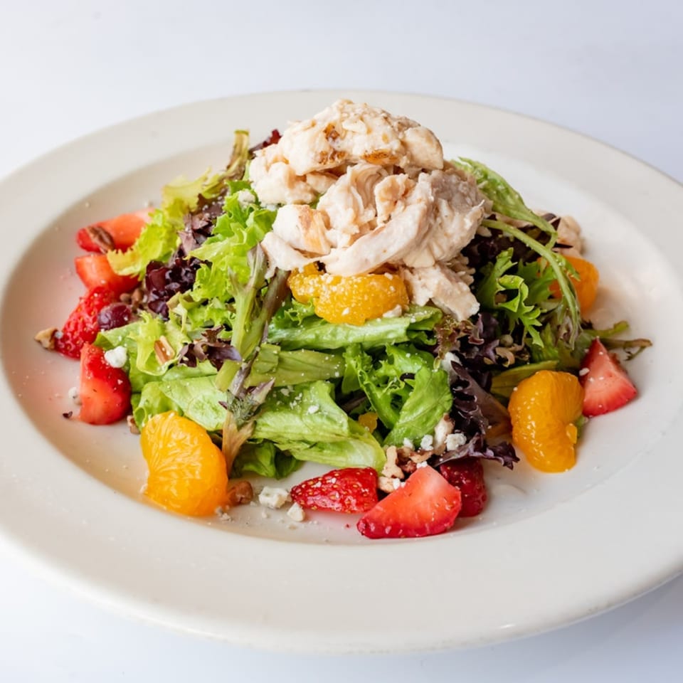 A fresh KupAJoe Cafe salad with chicken, strawberries, mandarin oranges, and feta cheese.
