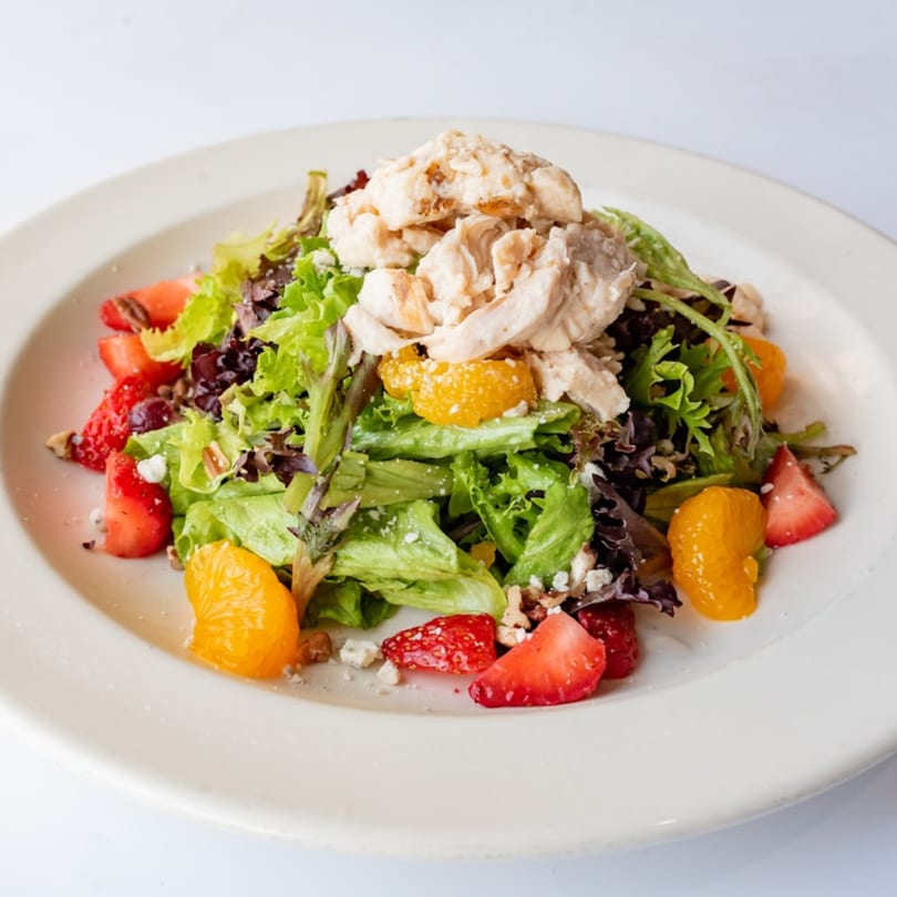 A fresh KupAJoe Cafe salad with chicken, strawberries, mandarin oranges, and feta cheese.